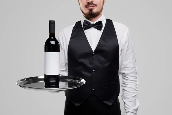 Elegant waiter serving bottle of wine — Stock Photo, Image