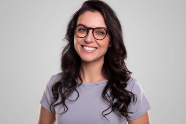 Gözlüklü mutlu kadın kameraya bakıyor.