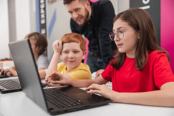 Kinderen met leerkracht die op laptops werken — Stockfoto