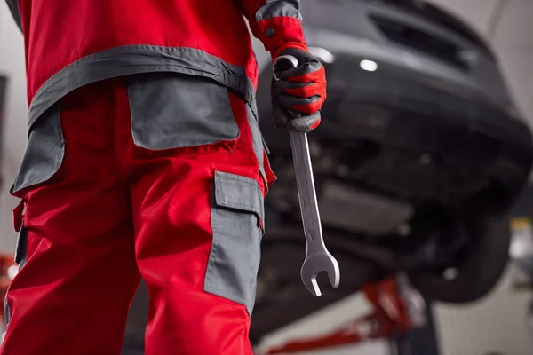 Unrecognizable mechanic with wrench in garage — Stock Photo, Image