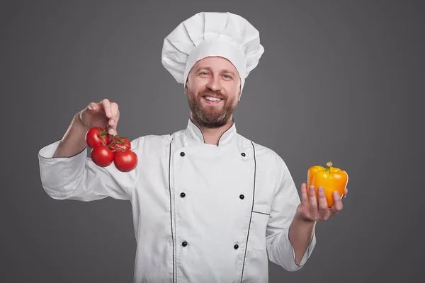 Cocinero alegre mostrando verduras frescas —  Fotos de Stock