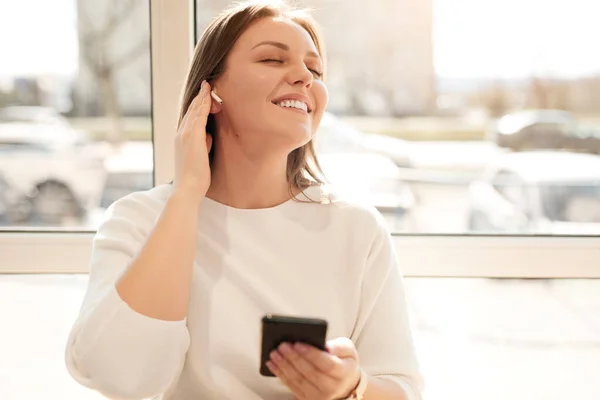 Mujer alegre escuchando música cerca de la ventana — Foto de Stock