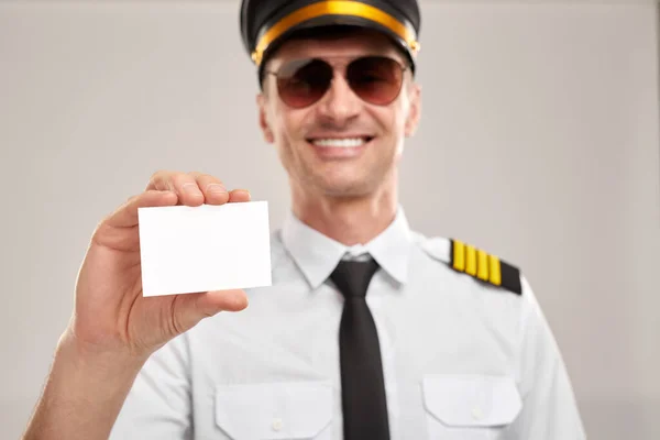 Χαμογελαστή πιλότος δείχνει κενή επαγγελματική κάρτα — Φωτογραφία Αρχείου