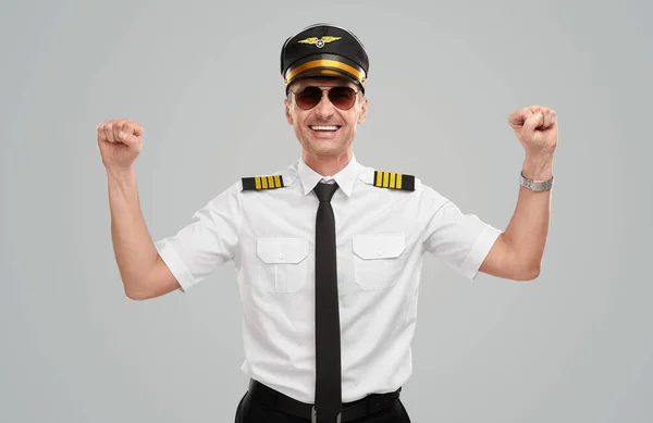 Веселый пилот в униформе сжимает кулаки — стоковое фото