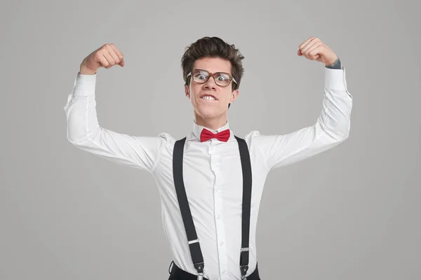 Funny nerd in formal outfit showing muscles — Stock Photo, Image
