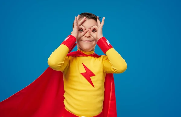 Glückliches Superhelden-Kind schaut durch die Finger — Stockfoto