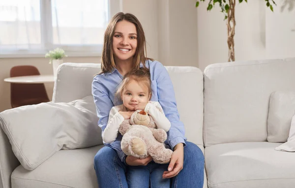 Glückliche Mutter und kleines Mädchen mit Spielzeug — Stockfoto