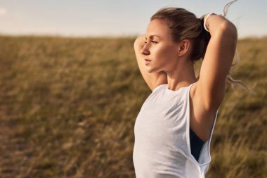 Yaz akşamları tarlada duran sakin kadın.