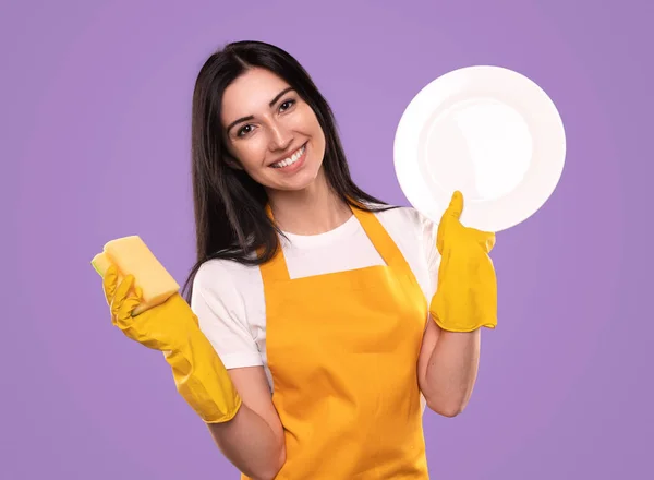 Fröhliche Hausfrau mit Schwamm und Teller — Stockfoto