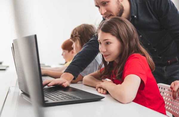 Schoolmeisje en leraar tijdens computerles — Stockfoto