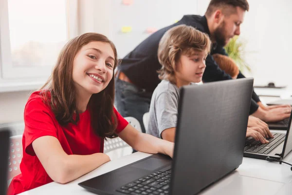 Colegiala feliz con portátil en el aula — Foto de Stock