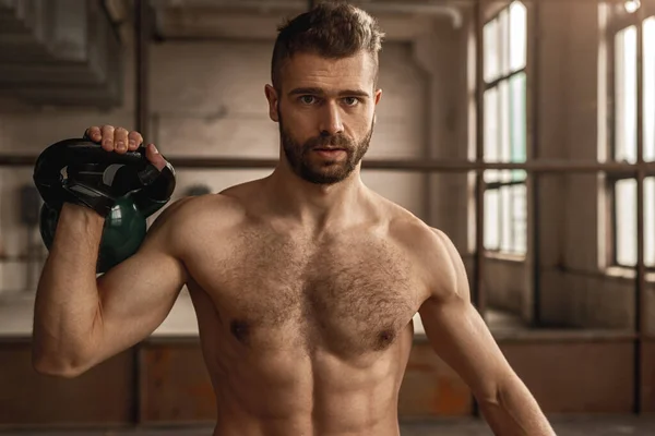 Forte uomo muscolare sollevamento kettlebell in palestra — Foto Stock