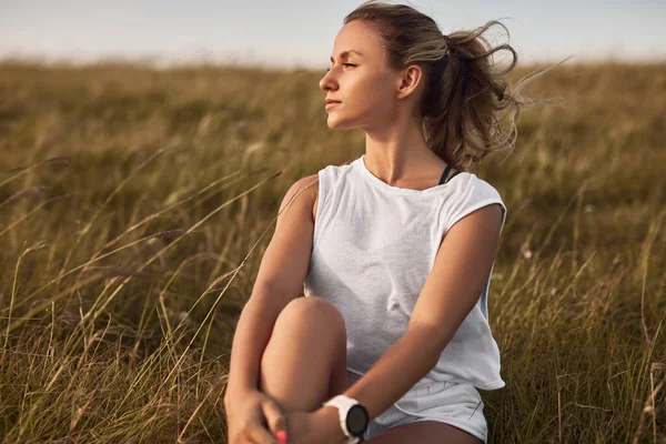 Donna sportiva che riposa sul campo — Foto Stock