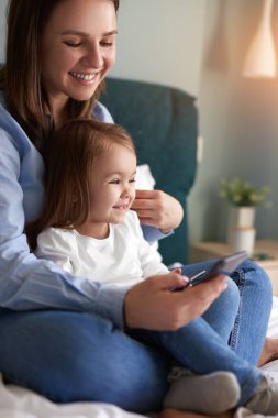 Akıllı telefonlu neşeli anne ve çocuk.