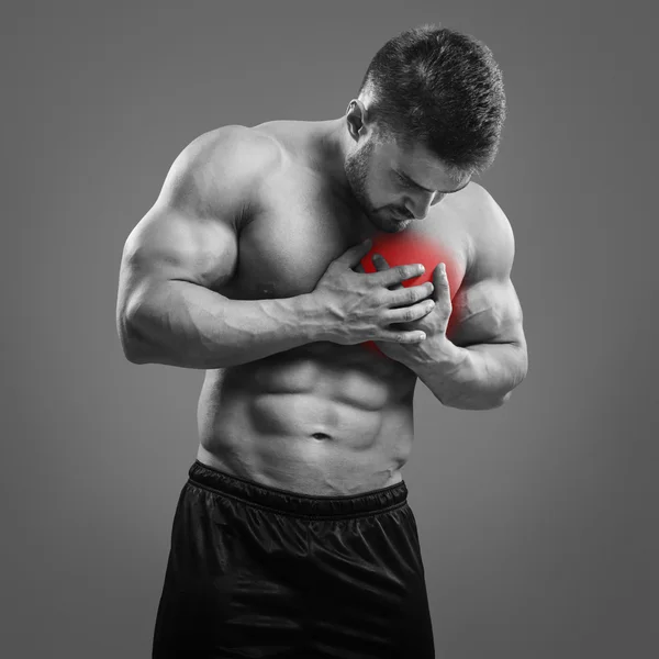 Uomo muscoloso senza maglietta con dolore al petto su sfondo grigio . — Foto Stock