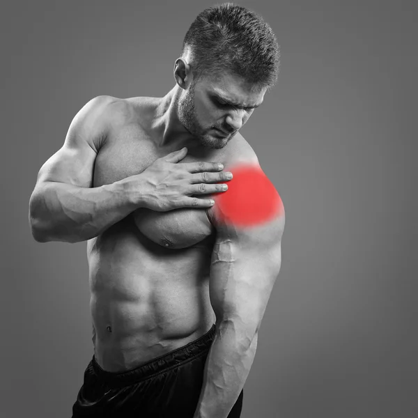 Muscular shirtless man with shoulder pain over gray background. — Stock Photo, Image