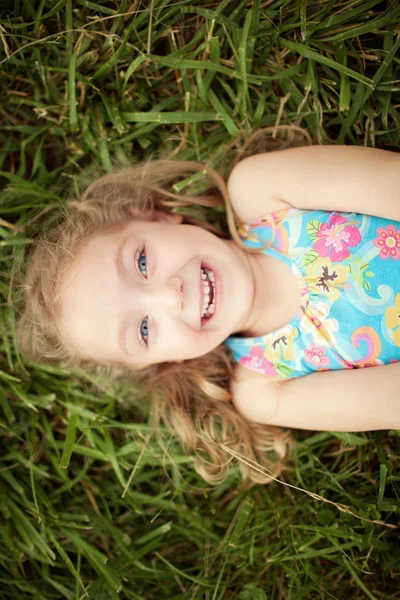 Вид зверху маленька дівчинка лежить на траві — стокове фото
