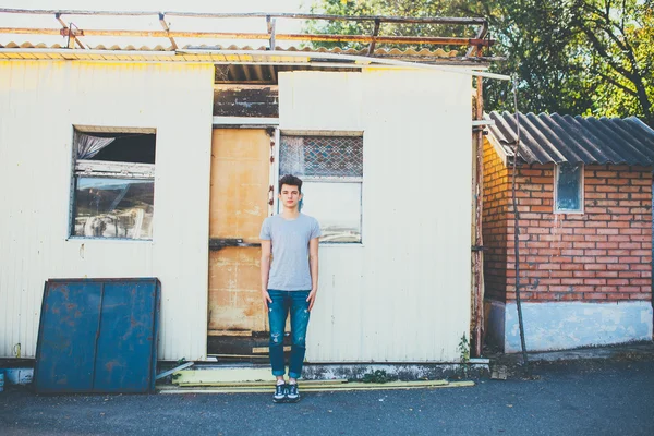 Young man standing still near abandoned building — 图库照片