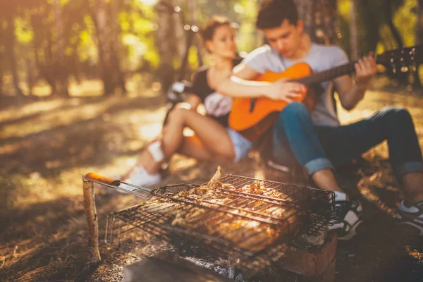 Teenage couple having a picnic and playing guitar — Zdjęcie stockowe
