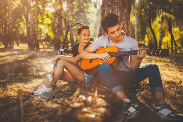 Adolescente casal fazendo um piquenique e tocando guitarra — Fotografia de Stock
