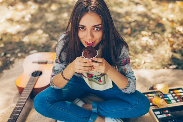 Creative young woman smiling with cupcake — Zdjęcie stockowe