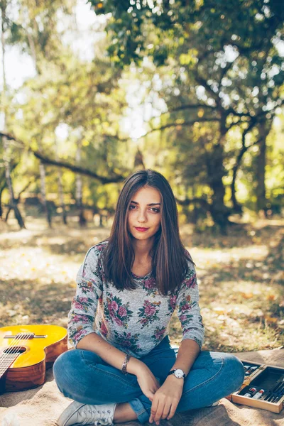Cute girl sitting outdoors at picnic — ストック写真