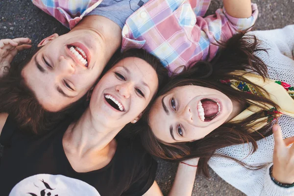 Bovenaanzicht van vrienden liggen en lachen — Stockfoto