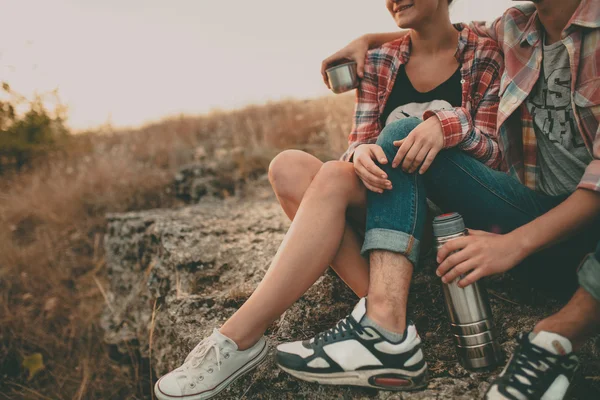 Cropped hipsters tendo uma xícara de chá na natureza . — Fotografia de Stock