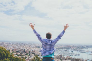 Arkadan görünüşü Palma şehir için eller yükselterek genç adam