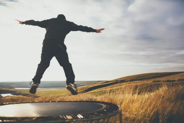 Mann springt auf Trampolin in Island aus dem Fokus. — Stockfoto