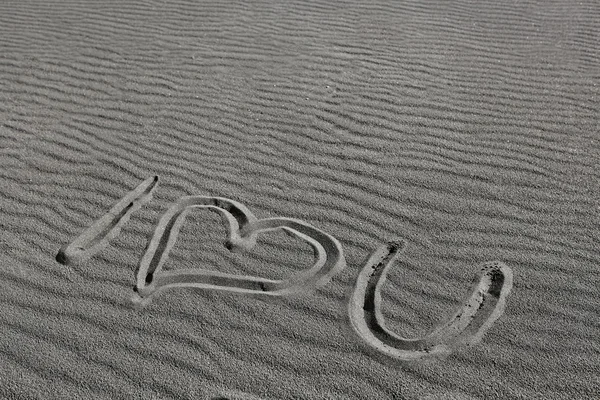 Ik hou van je, getrokken op het zand van een zwarte strand — Stockfoto