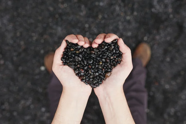 Handen en zand in de vorm van het hart — Stockfoto