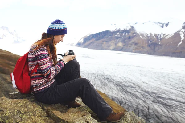 İzlanda'daki buzul yakın oturan sırt çantası olan kadın. — Stok fotoğraf