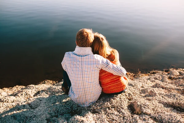 Vista posteriore di giovane ragazza e ragazzo seduto sul lago — Foto Stock