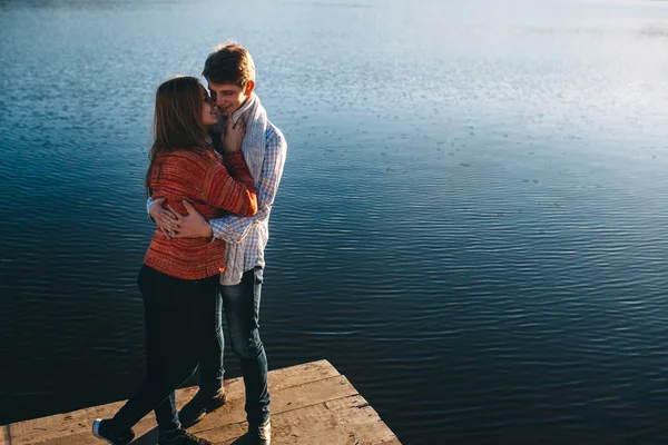 Paar knuffelen elkaar op een pier — Stockfoto