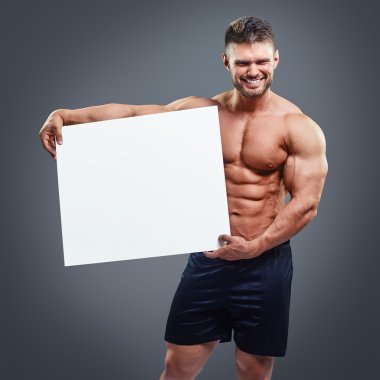 Boş beyaz poster tutan kas genç adam