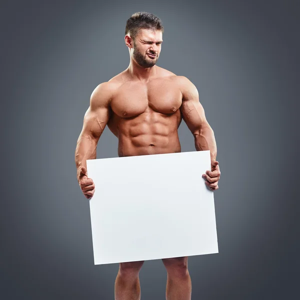 Atleet met spieren houden van lege witte poster — Stockfoto