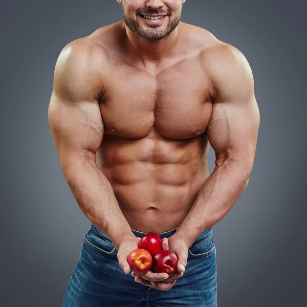 Man bodybuilder houden een vers fruit — Stockfoto