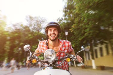 Yakışıklı genç sürme scooter gülümseyen