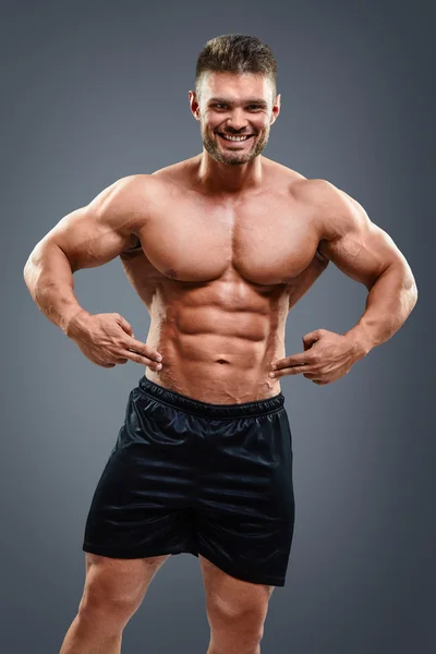 Bodybuilder man pointing at abs — Stock Photo, Image
