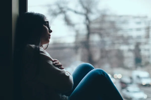 Adolescente chica mirando por la ventana — Foto de Stock