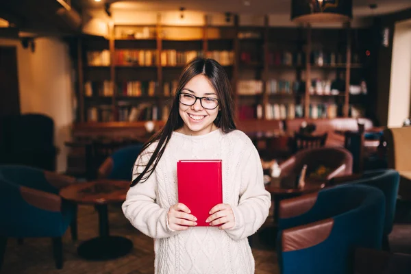 Piękne kobiece studenta gospodarstwa książki w bibliotece — Zdjęcie stockowe