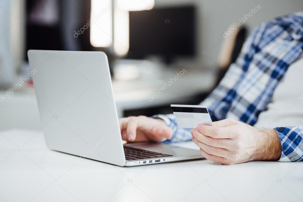 Man Shopping Online Using Laptop and Credit Card