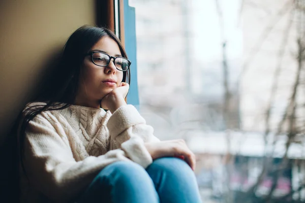 Chica triste mirando por la ventana —  Fotos de Stock