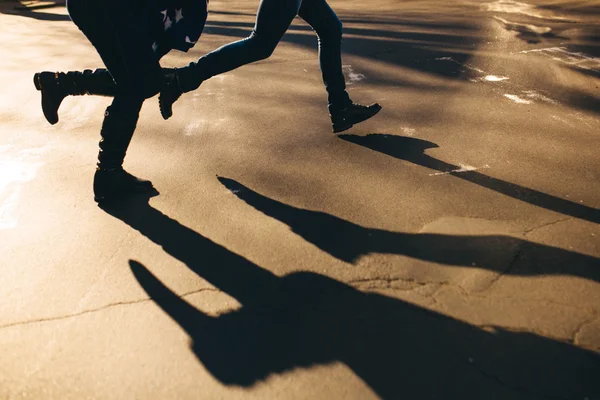 Abstract shadows of running couple on street — Stock Photo, Image