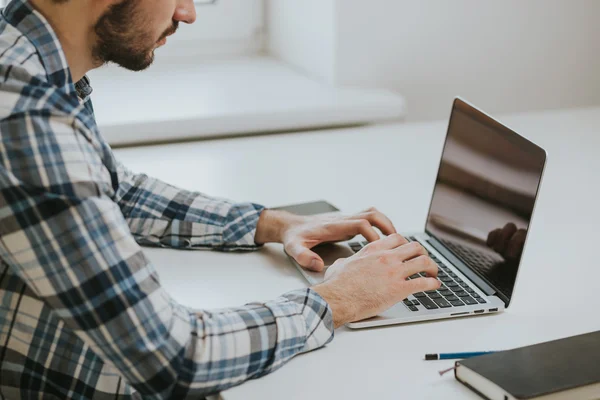 Jeune homme travaillant sur son ordinateur portable — Photo