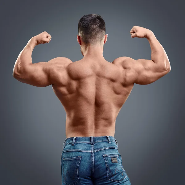 Strong muscular man back on grey background — Stock Photo, Image