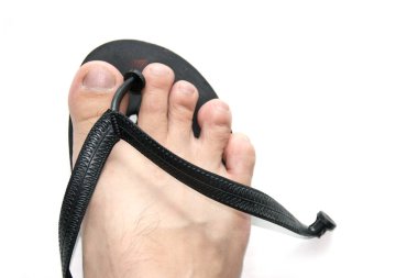 Siyah lastik terliklerin üzerindeki ayak beyaz arkaplanda izole edilir.