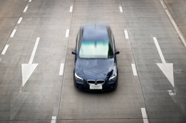 Üstten mavi araba yarışı ve yolda beyaz ok işareti