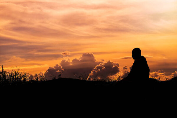 Silhouette - The Buddhist Monk Meditation and clouds evening sky